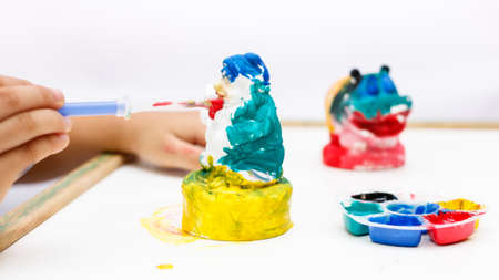 The kid painting color on the plaster statueの写真素材