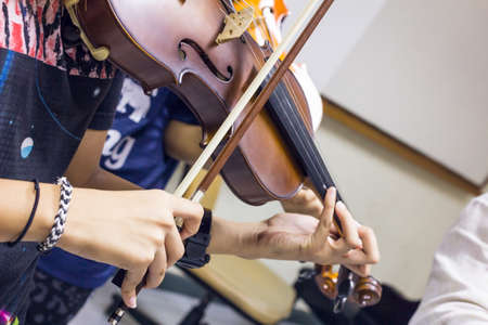Two girl playing violin in classroomの写真素材