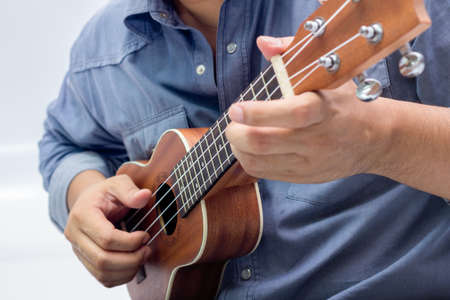 The man is playing the brown ukuleleの写真素材