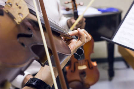 Two girl playing violin in classroomの写真素材
