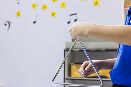 The children is playing the triangleの写真素材