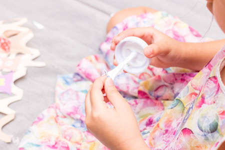 The little girl is gluing color paper. The little girl makes handcraft.の写真素材