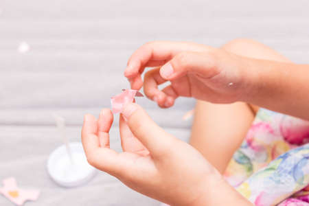 The little girl is gluing color paper. The little girl makes handcraft.の写真素材