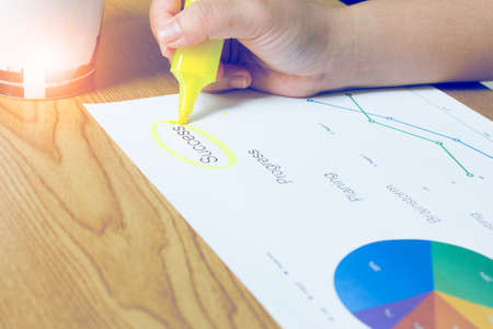 Hand highlighting at business document on the tableの写真素材