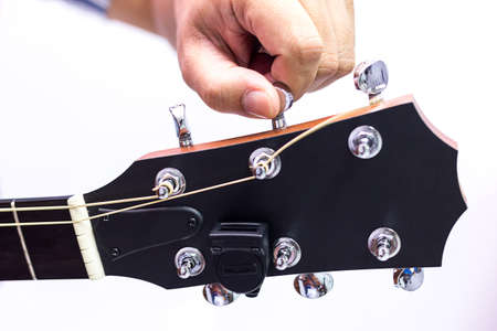 Person tuning a guitar over white background in selective focusの写真素材
