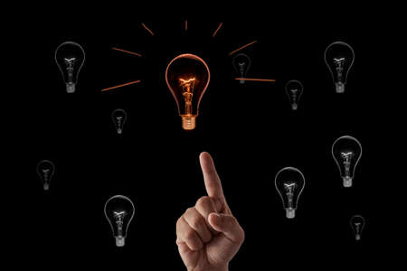 Hand with incandescent bulbs on black backgroundの写真素材