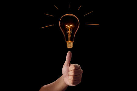 Hand with incandescent bulbs on black backgroundの写真素材