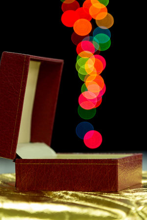 Red gift box on dark background with colour bokeh