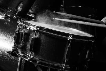 The man is playing drumset in low light background.の写真素材