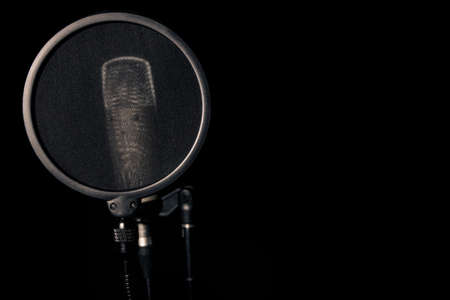 Professional condenser microphone with pop filter in black backgroundの写真素材