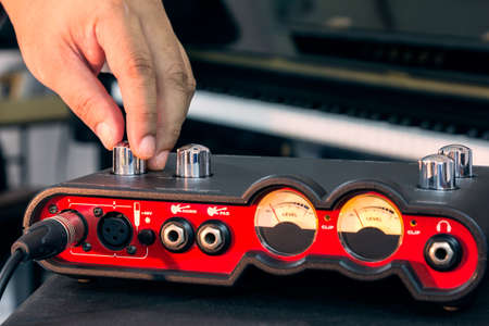 Hand adjust volume of the audio interface for Home recording, external sound card.の写真素材