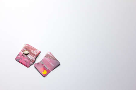 Closeup of the broken red credit card on the white background.の写真素材