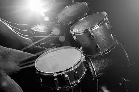 The man is playing drum set in low light background, black and white.の写真素材