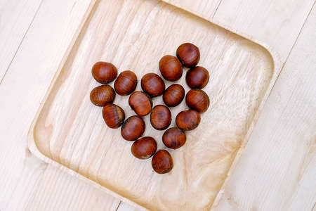 Chestnut LOVE in dish Wooden on the Tableの写真素材