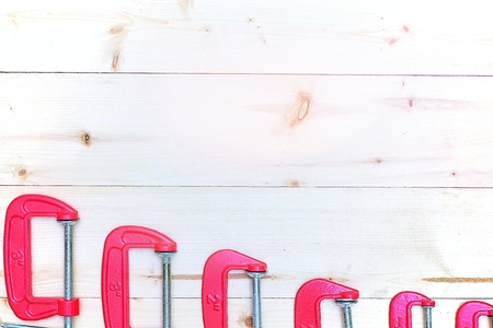 red c-clamps on wooden background with copy spaceの写真素材