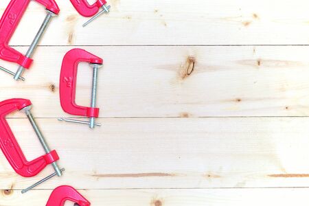 red c-clamps on wooden background with copy spaceの写真素材