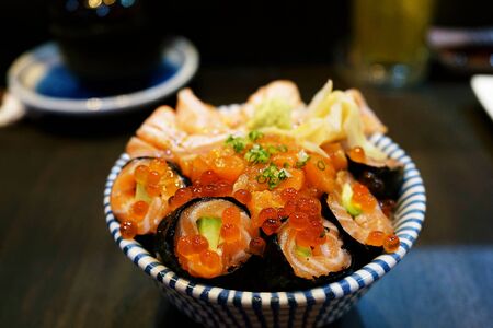 Salmon ikura don and salmon rolls on wooden background, rice bowl Japanese seafood donburi with fresh salmon sashimi and red caviarの写真素材