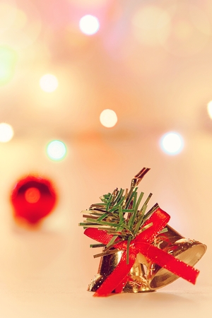 Jingle gold bell ,Christmas decoration with against defocused backgroundの写真素材
