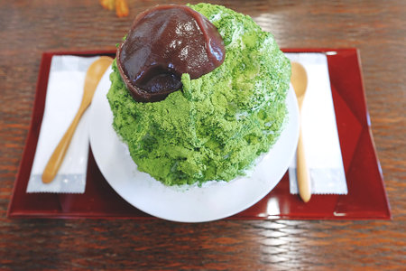 Summer desserts, matcha green tea shaved ice topped with matcha powder and red bean paste and served...