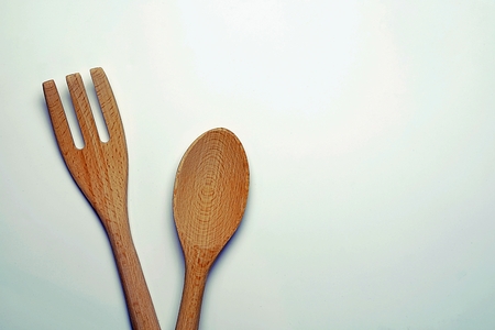 top view image of wooden spoon and wooden fork on the white desk, Different wooden kitchen tools on the table with copy spaceの写真素材