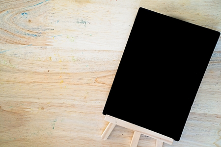 Top view of Small black empty chalkboard on wooden textured background. Blank Blackboardの写真素材