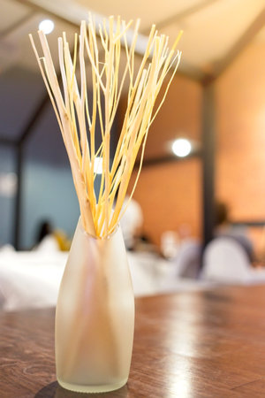 Recycling concept, Home decoration, yellow dry branches put in cut translucent bottle vase. decorate, fragrance oil with dry flower in bottom aroma on wooden tableの写真素材