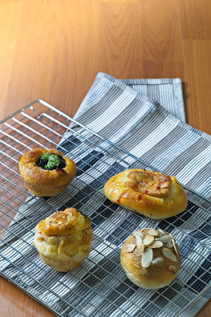 Freshly Baked danish pastry on wooden background, assorted bread and pastry, Different kinds of bread rolls. Kitchen or bakery poster design with copy spaceの写真素材