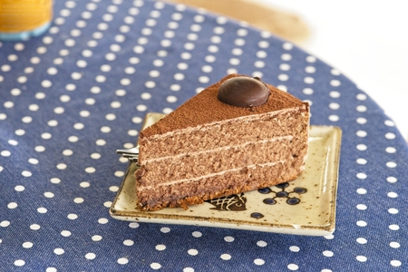 Delicious chocolate cake on plate on vintage table with copy space. A cafe scene background. Piece of chocolate cakeの写真素材