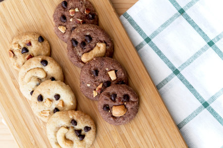 Delicious Chocolate Chip Cookies on wooden tray, Tasty Homemade cookies on wooden table, dessert with checkered tablecloth. Top view with copy spaceの写真素材