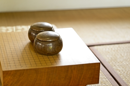 Chinese, Japan, Korean board game GO. Go or wei-Chi - WeiQi traditional asian board game. Empty go game board with black and white stone in bow on Japanese style room, close up view of playing.の写真素材