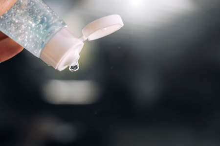Alcohol hand washing gel protects against germs and viruses. Background is blurred and has a light effect on the top right. Focus on alcohol and spray alcohol hand washing gel.の写真素材