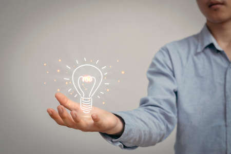 Man holding icon light bulb,idea concept, intelligence that is intelligent and smart, Presenting new ideas.の写真素材