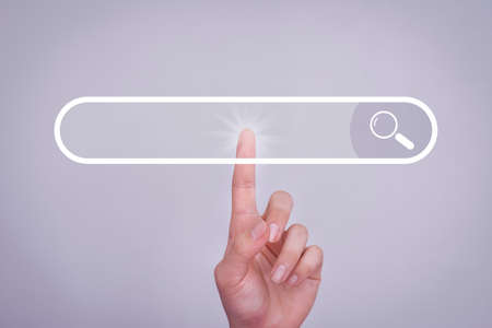 Search button on virtual screen pressed with finger on white background and shows the internet connection, international and global social media. Search concepts searched on the internet.の写真素材
