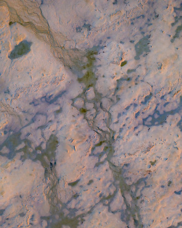 aerial drone shot of crater with multiple holes, water, and sand