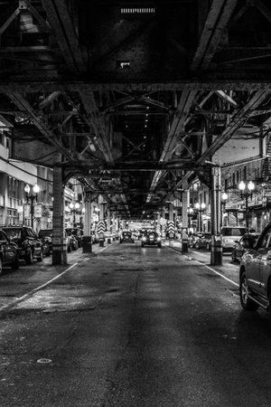 street with cars under train tracks and metro in chicago