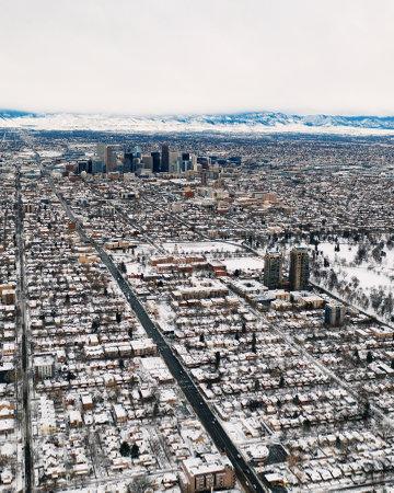 wide aerial drone shot of cityscape skyline covered in snow after a blizzardの写真素材