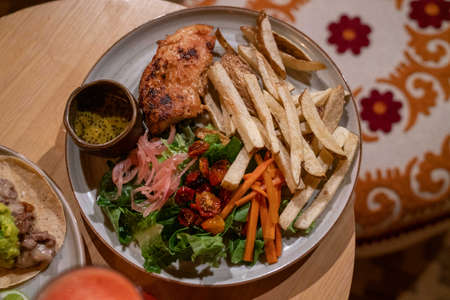 tasty chicken entree with a side salad and french friesの写真素材