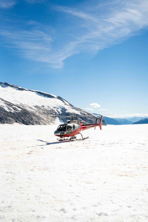 epic shot of helicopter landing on snow in the middle of a bright sunny day in the arcticの写真素材