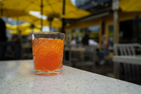 beautiful short glass cocktail with orange and pink colors and iceの写真素材