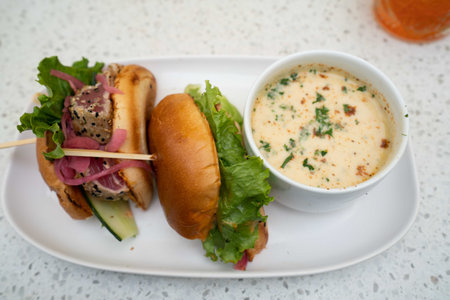 delicious tuna burger with a side soup at an outdoor restaurantの写真素材