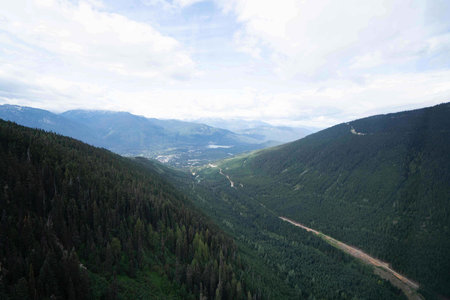 vast mountain landscape with green trees and nature everywhere along with large river in middle and...