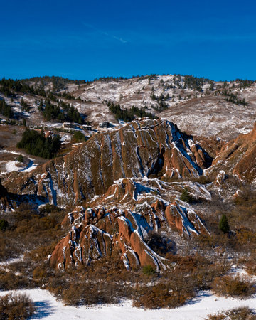 wide angle capture of beautiful snow covered red rock peaks on a bright blue dayの写真素材
