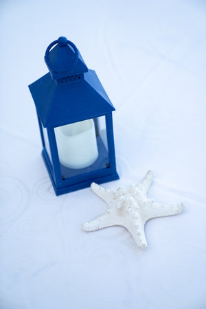 beach house decoration showing a beautiful starfish and small candle inside of blue house enclosureの写真素材