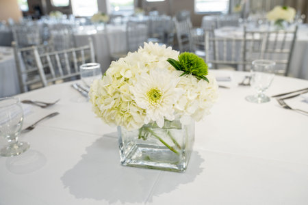 luxurious centerfold vase with white and green flowers at a beautiful event on a yacht or indoor space in the summerの写真素材