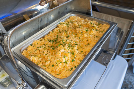 tray of yellow rice with green garnish on top at a fine dining wedding eventの写真素材