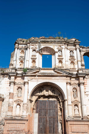 church ruins showing facade with moon behind window in ancient spanish colonial town during the dayの写真素材