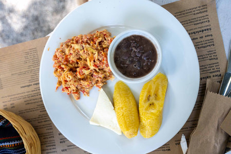 breakfast platter of eggs plantains cheese and beansの写真素材