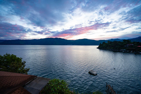 magnificent looking sunrise colors on a lake in south american nature landscape in guatemalaの写真素材