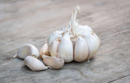 Close up of purple garlic on wooden background (Alliums, Alliaceae)の写真素材