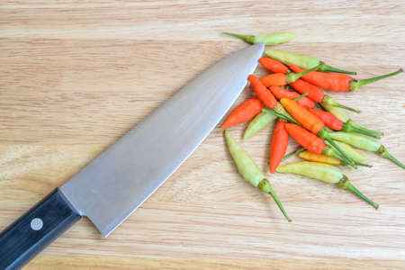 Chilies on a wooden cutting boardの写真素材